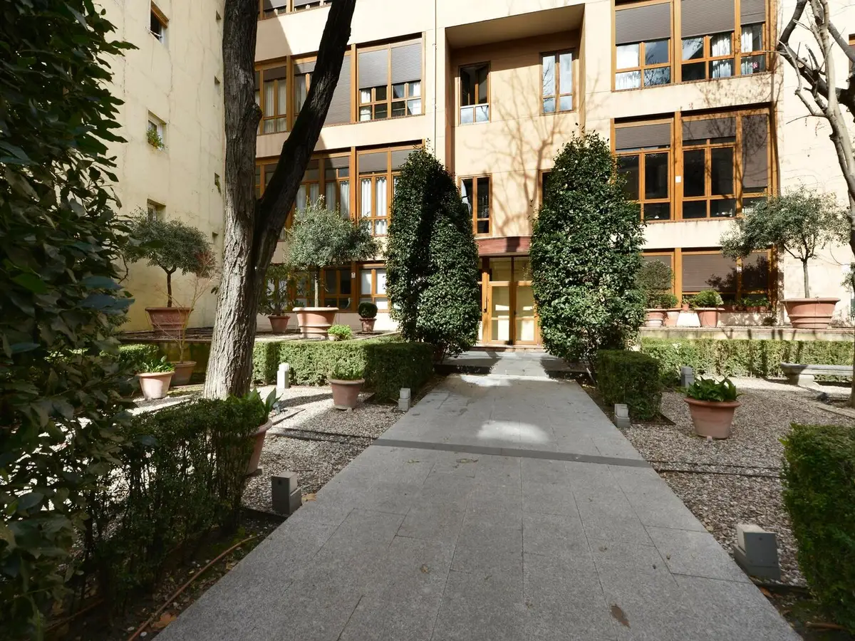 Cour intérieure arborée d'une résidence avec son allée centrale et ses haies